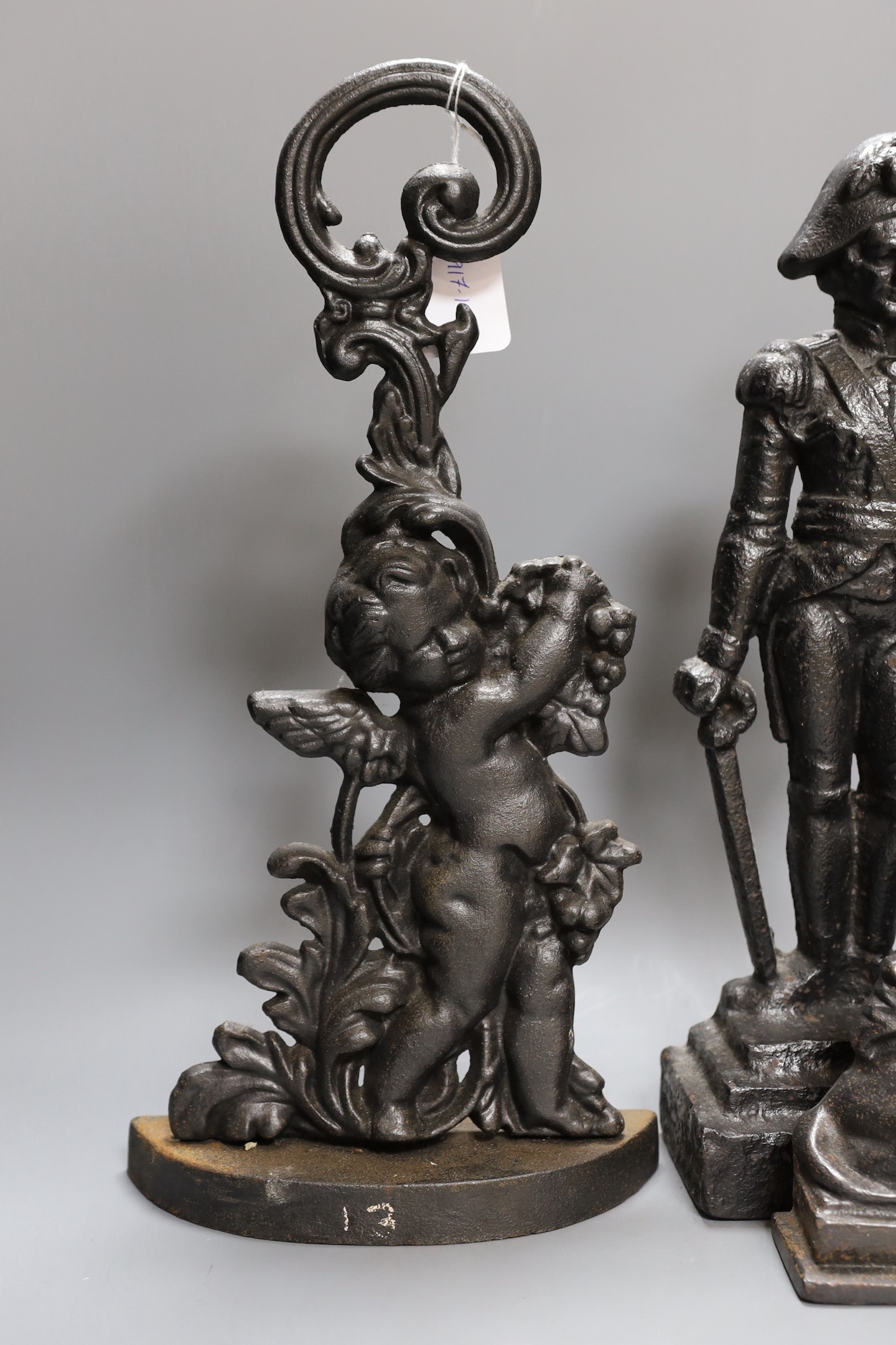 A cherubic cast iron door stop, another of Napoleon, a sphinx and another,(4), Napoleon 40 cms high